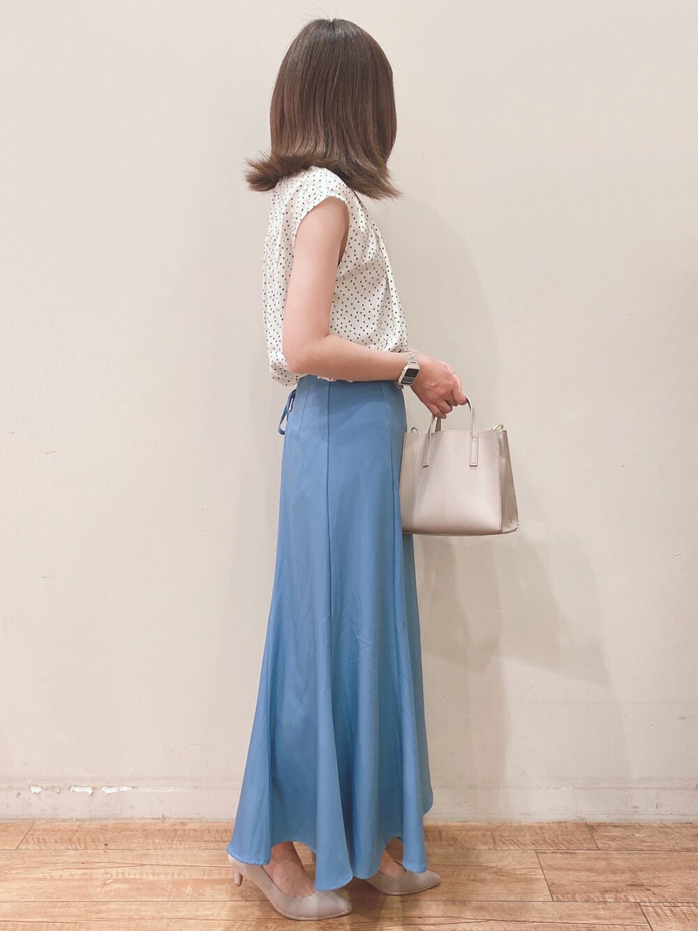 ベージュ系のシャツ/ブラウス、ブルー系のスカート、ベージュ系のパンプスを着用したレディースの春コーディネートの2枚目の写真