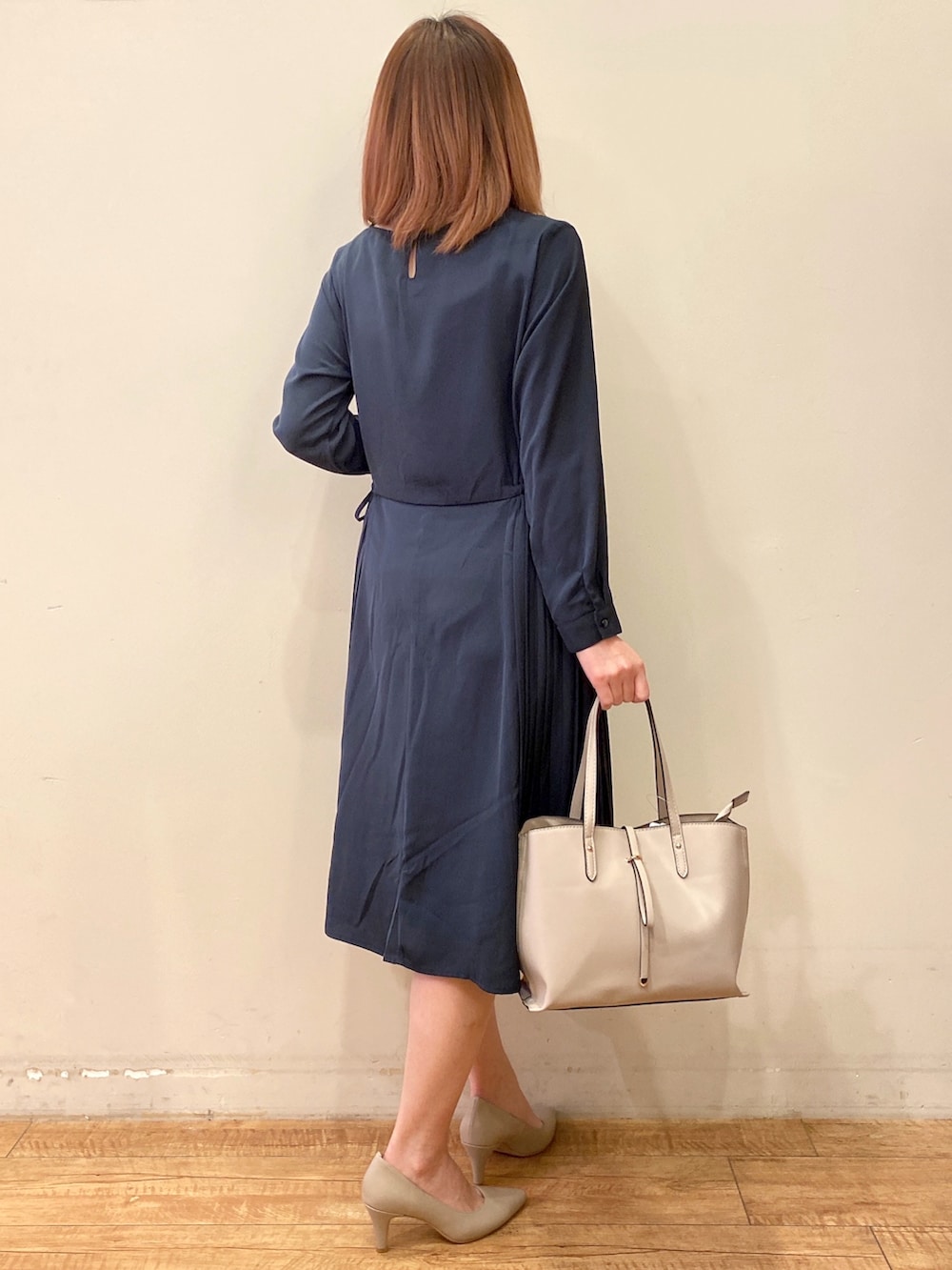 ブルー系のワンピース、グレー系のトートバッグ、グレー系のパンプスを着用したレディースの冬コーディネートの2枚目の写真