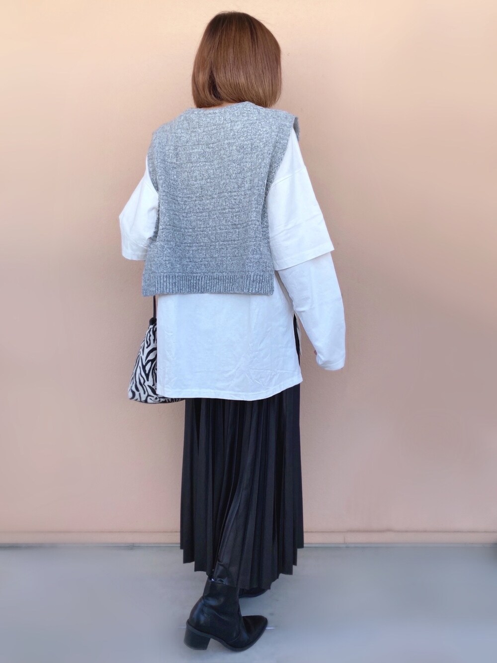 ブラック系のスカート、ブラック系のショルダーバッグ、ブラック系のブーツを着用したレディースの冬コーディネートの3枚目の写真