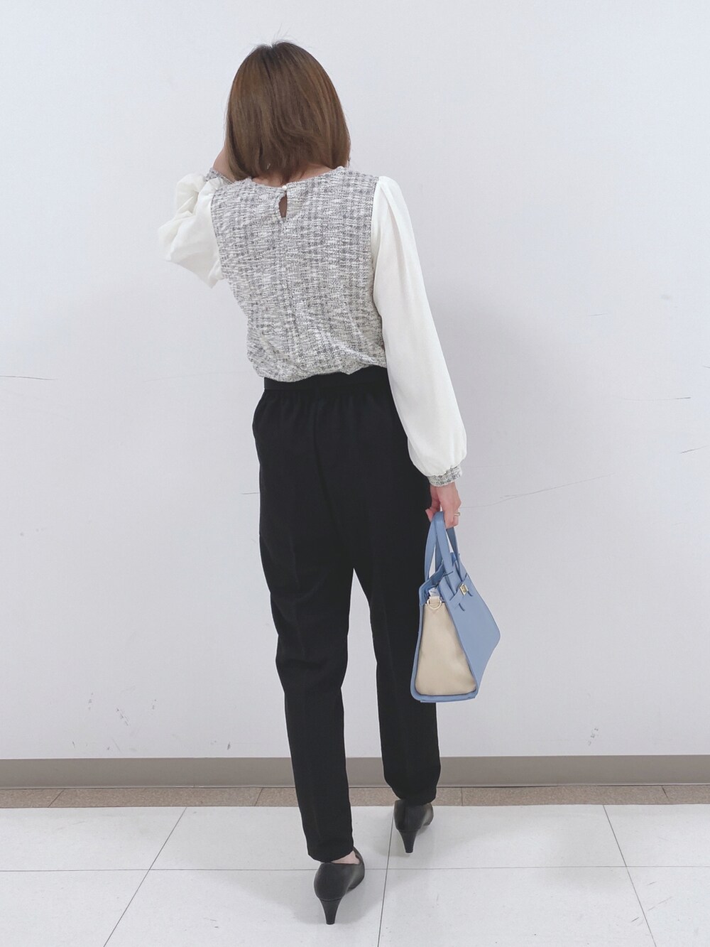 ブラック系のその他パンツ、ブラック系のパンプス、ブルー系のトートバッグを着用したレディースの冬コーディネートの3枚目の写真
