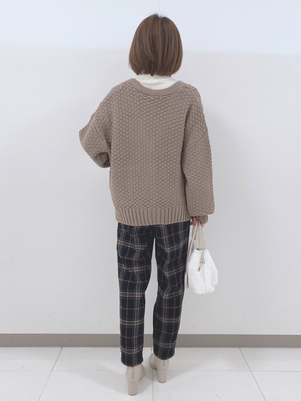 ホワイト系のニット/セーター、ベージュ系のカーディガン/ボレロ、ブルー系のその他パンツを着用したレディースの秋コーディネートの3枚目の写真