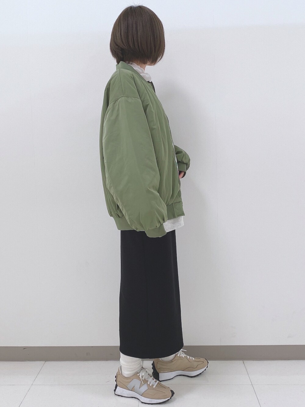 グレー系のスウェット、グリーン系のブルゾン、ホワイト系のTシャツ/カットソーを着用したレディースの秋コーディネートの2枚目の写真