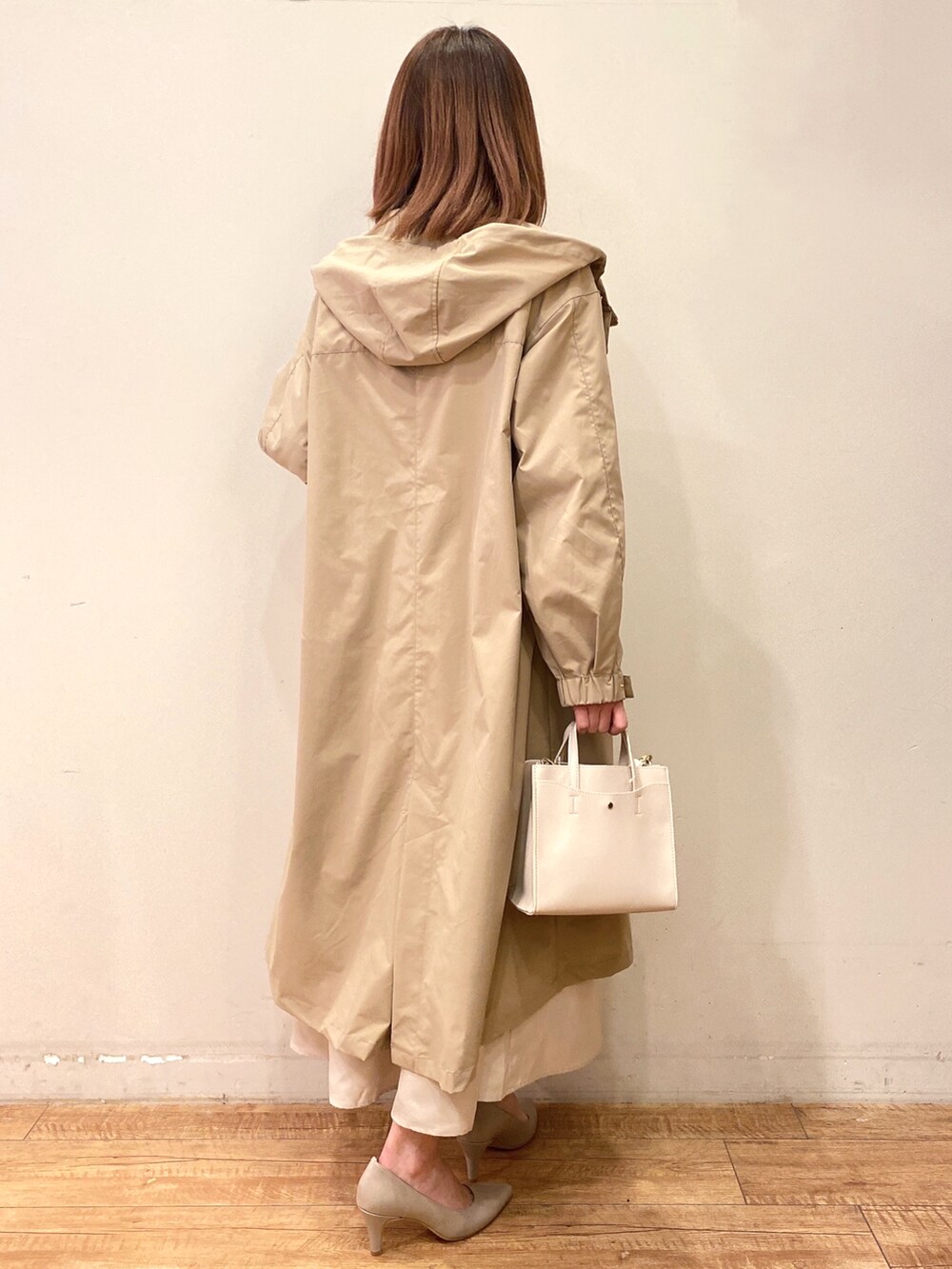 ベージュ系のワンピース、イエロー系のその他アウター、グレー系のパンプスを着用したレディースの冬コーディネートの2枚目の写真