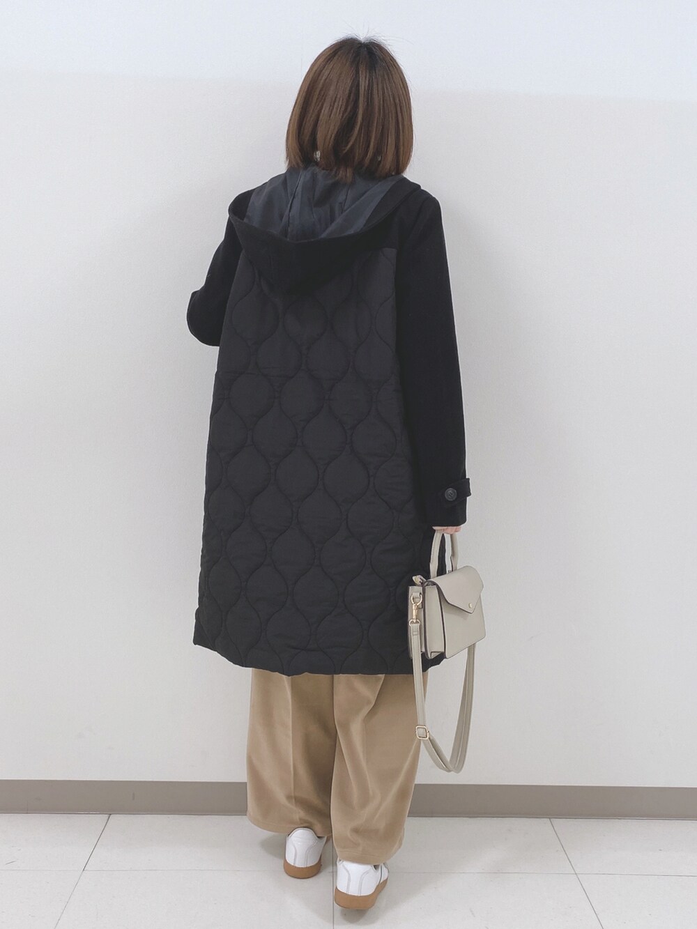 ブラック系のニット/セーター、ブラック系のその他アウター、ベージュ系のその他パンツを着用したレディースの冬コーディネートの3枚目の写真