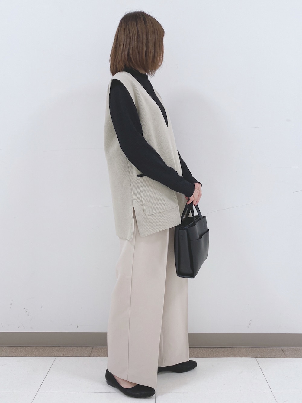 ベージュ系のベスト、ブラック系のTシャツ/カットソー、ベージュ系のその他パンツを着用したレディースの冬コーディネートの2枚目の写真