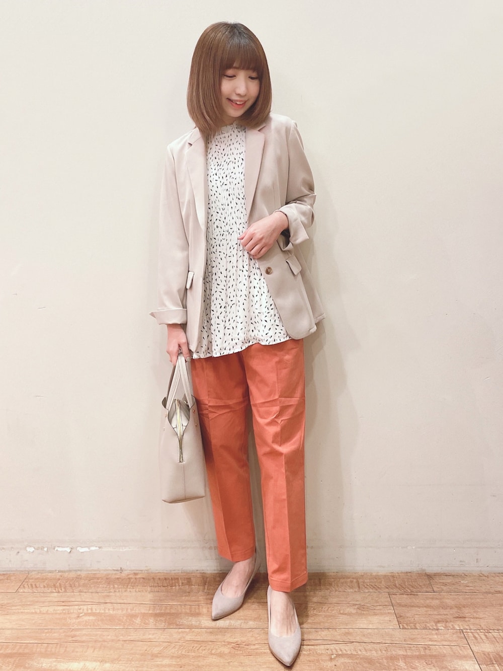 ベージュ系のテーラードジャケット、グレー系のトートバッグ、オレンジ系のその他パンツを着用したレディースの春コーディネートの4枚目の写真