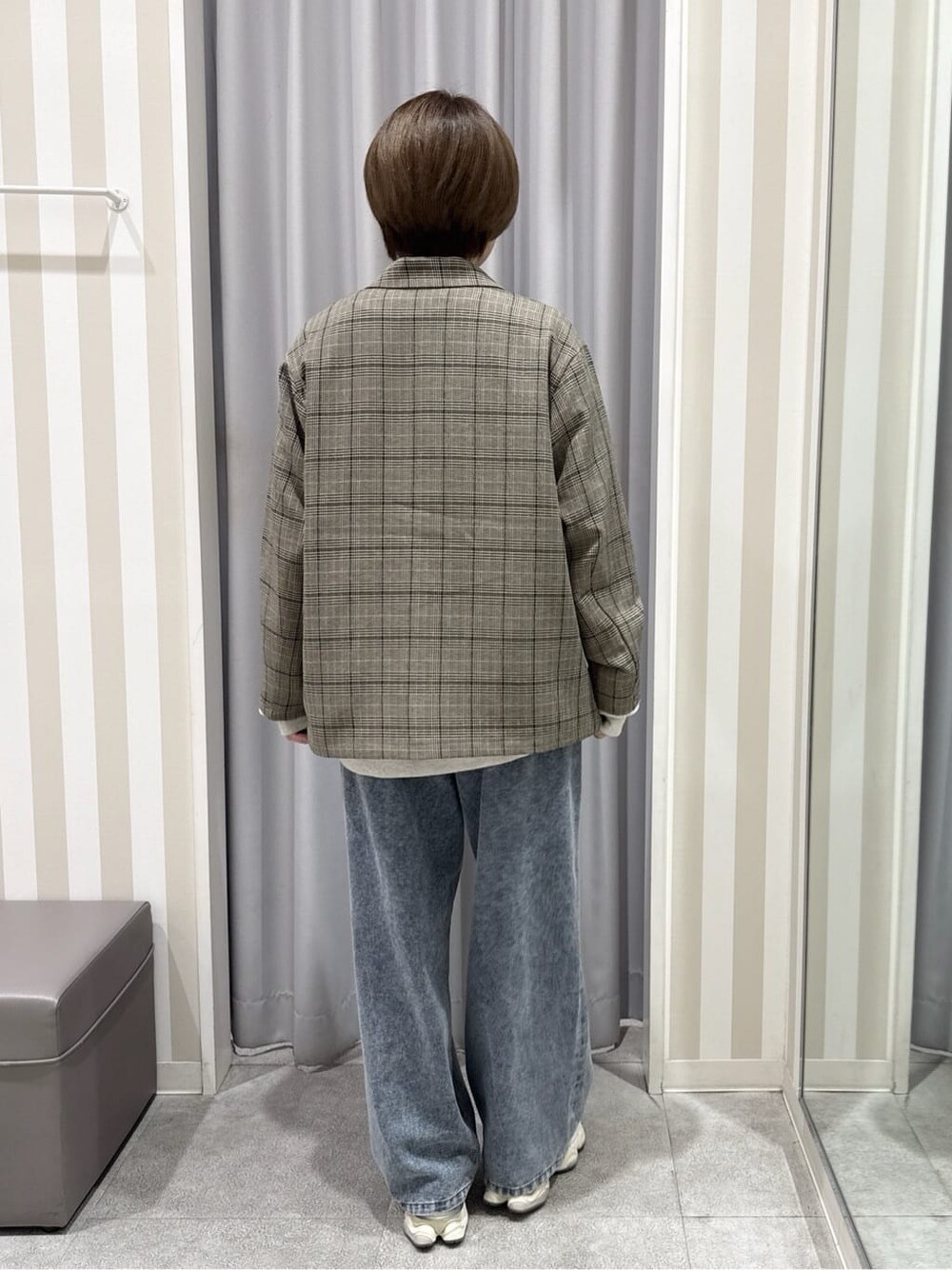 ベージュ系のテーラードジャケット、ホワイト系のスウェット、ブルー系のデニムパンツを着用したレディースの秋コーディネートの3枚目の写真