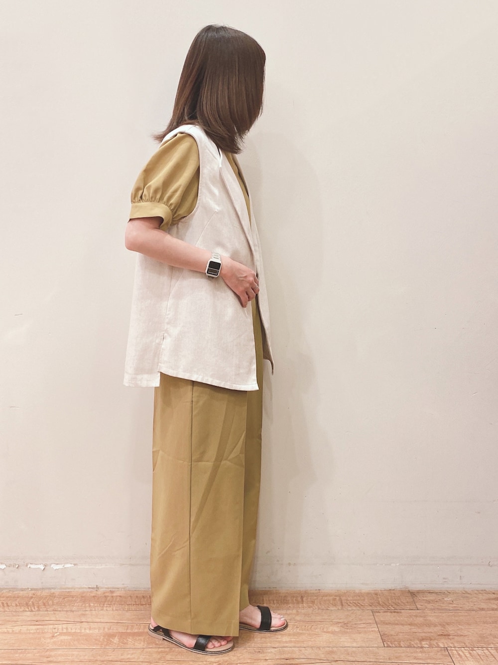 イエロー系のシャツ/ブラウス、イエロー系のその他パンツ、ベージュ系のベストを着用したレディースの春コーディネートの2枚目の写真