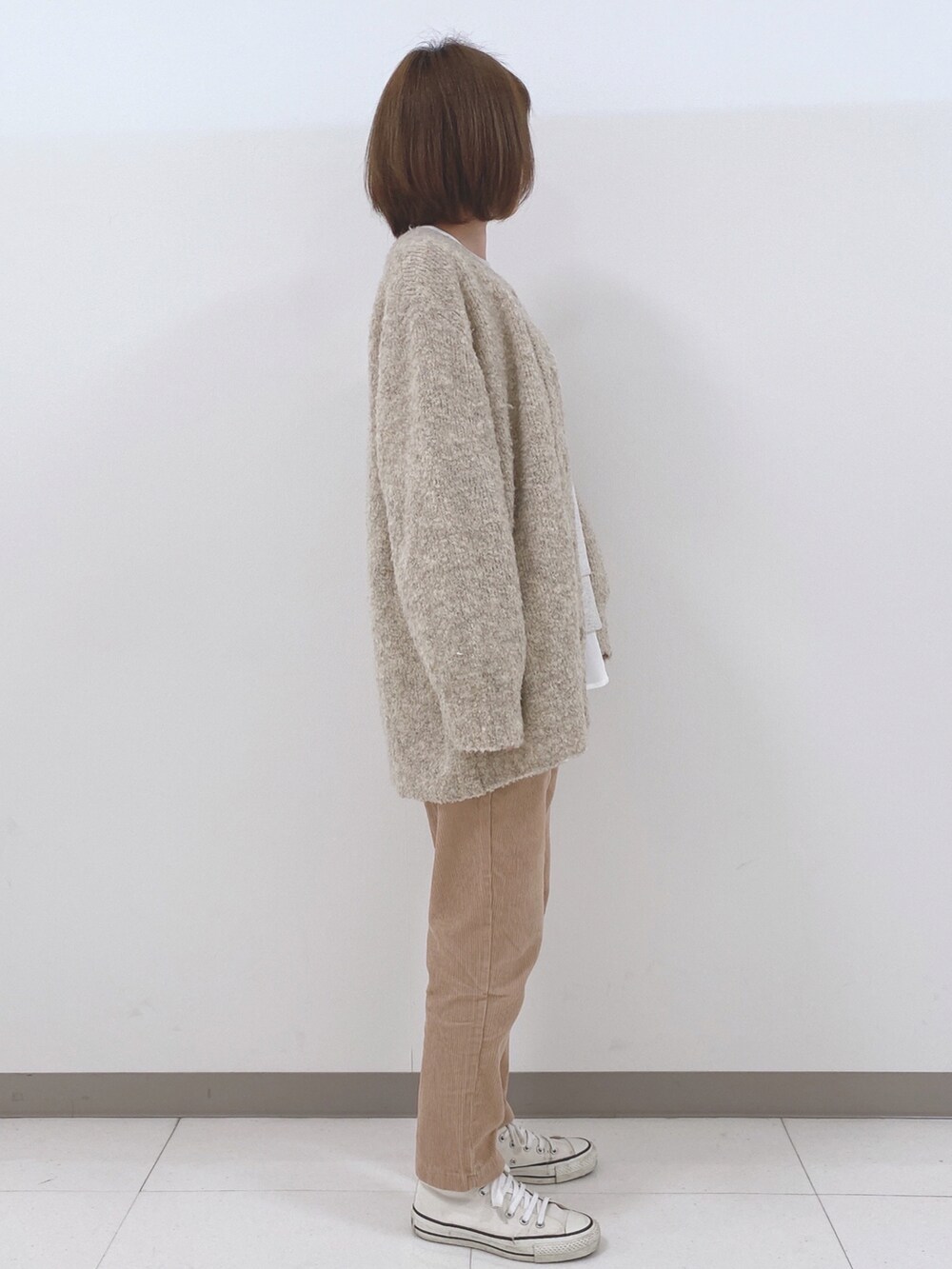 ベージュ系のカーディガン/ボレロ、グレー系のスウェット、ホワイト系のシャツ/ブラウスを着用したレディースの秋コーディネートの2枚目の写真