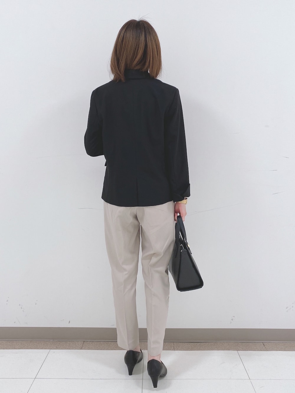 ブラック系のテーラードジャケット、ホワイト系のシャツ/ブラウス、ベージュ系のその他パンツを着用したレディースの冬コーディネートの3枚目の写真