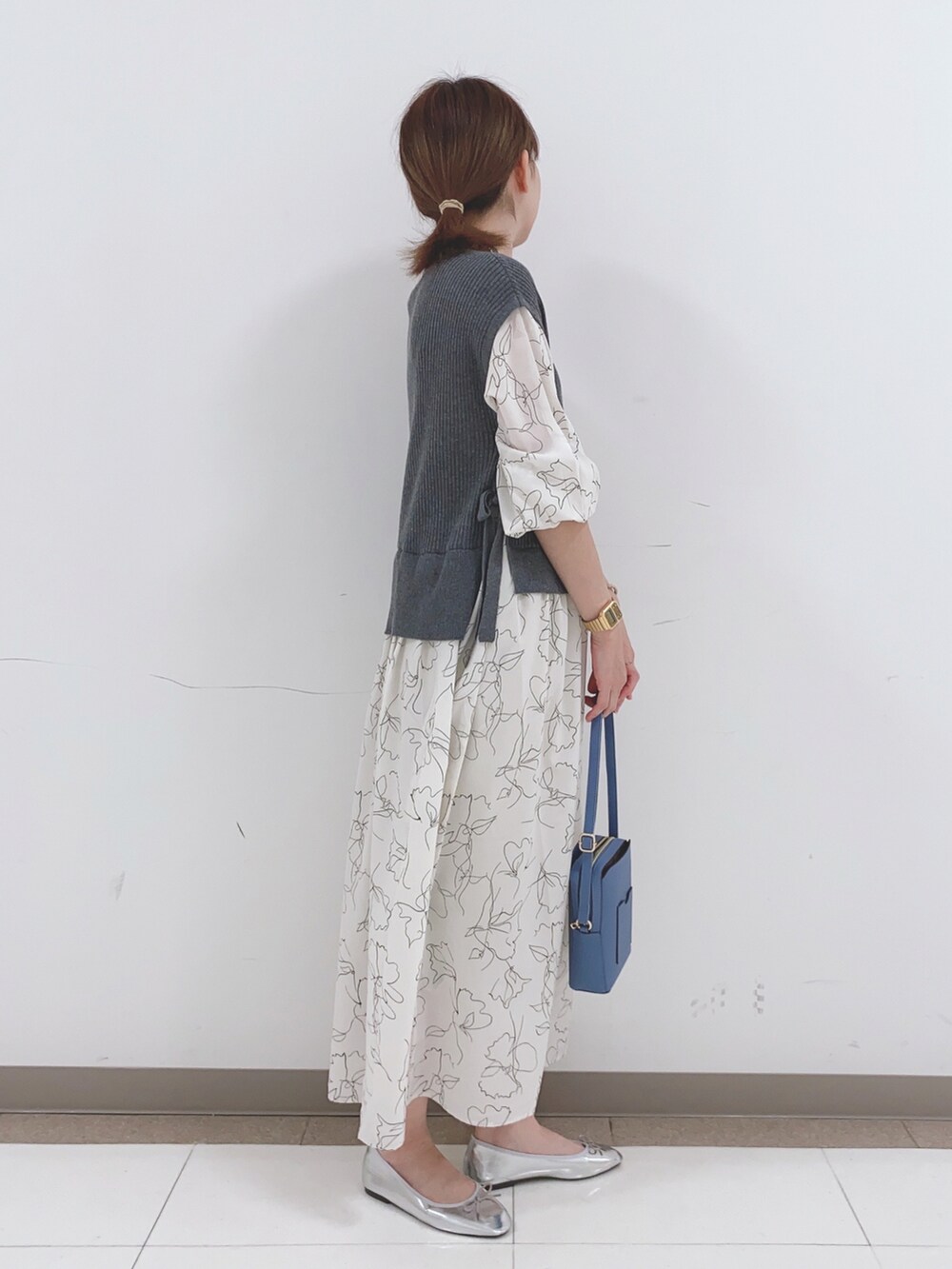 グレー系のワンピース、ブルー系のショルダーバッグを着用したレディースの春コーディネートの2枚目の写真