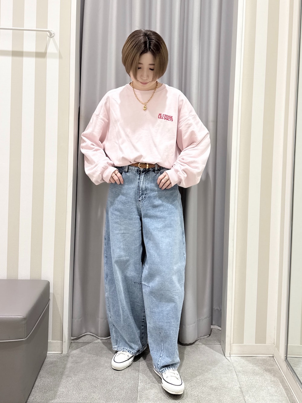 ピンク系のスウェット、ホワイト系のその他アウター、ブルー系のデニムパンツを着用したレディースの秋コーディネートの4枚目の写真