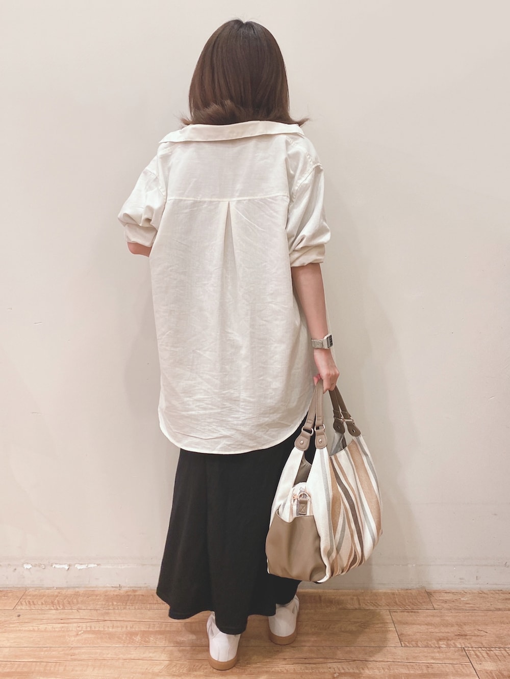 グリーン系のTシャツ/カットソー、ホワイト系のシャツ/ブラウス、ブラック系のスカートを着用したレディースの春コーディネートの3枚目の写真