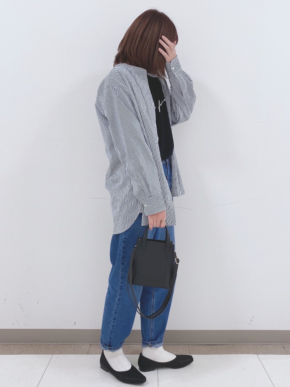 ブラック系のTシャツ/カットソー、ブルー系のシャツ/ブラウス、ブルー系のデニムパンツを着用したレディースの春コーディネートの2枚目の写真