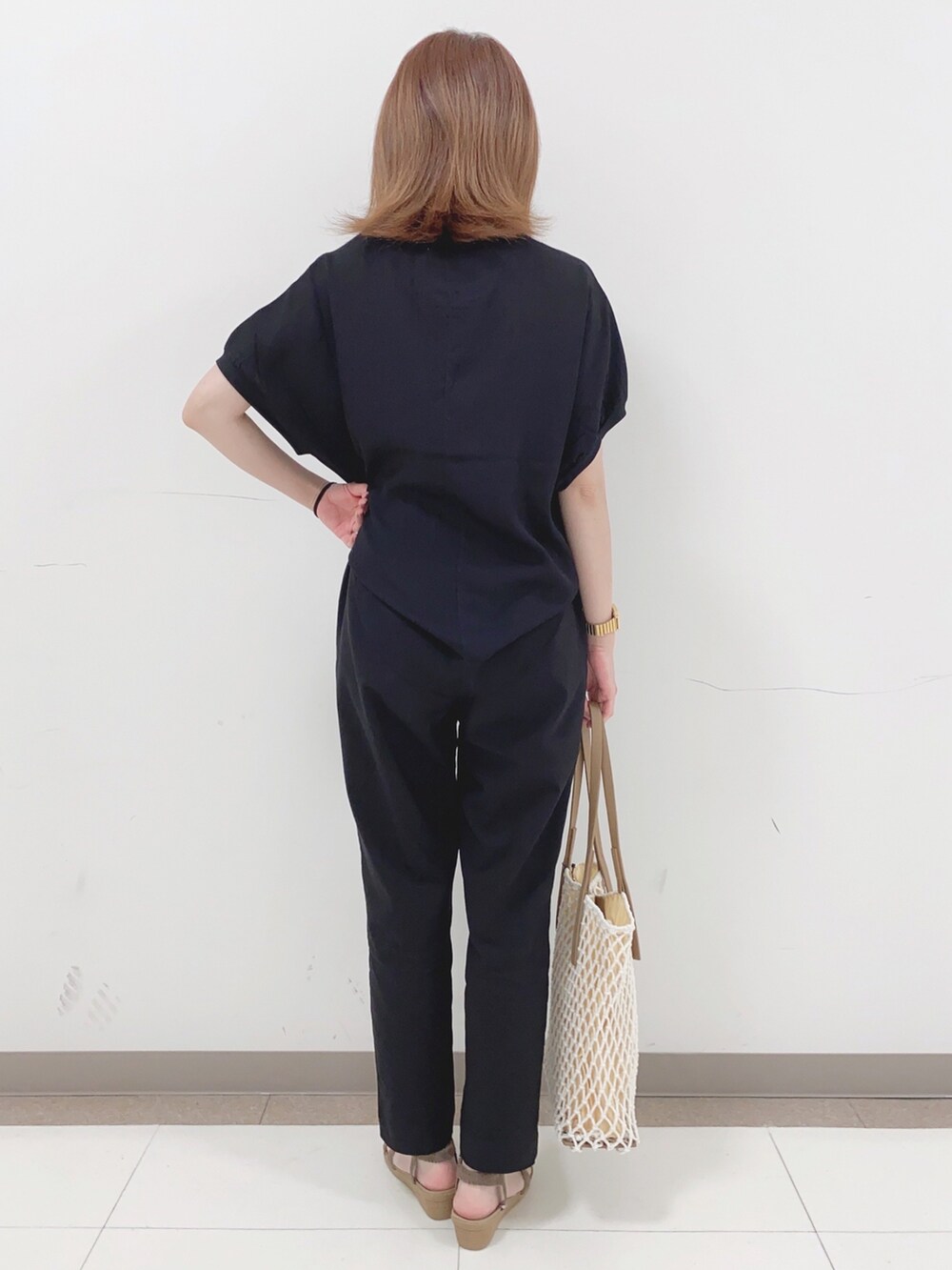 ブラック系のその他パンツ、ベージュ系のサンダル、ホワイト系のトートバッグを着用したレディースの春コーディネートの3枚目の写真