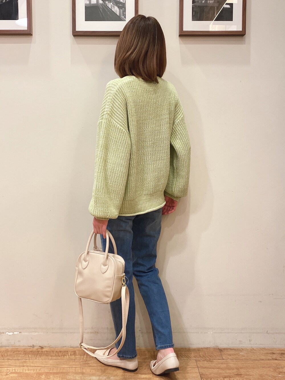 グリーン系のニット/セーター、ブルー系のデニムパンツ、ホワイト系のショルダーバッグを着用したレディースの冬コーディネートの3枚目の写真