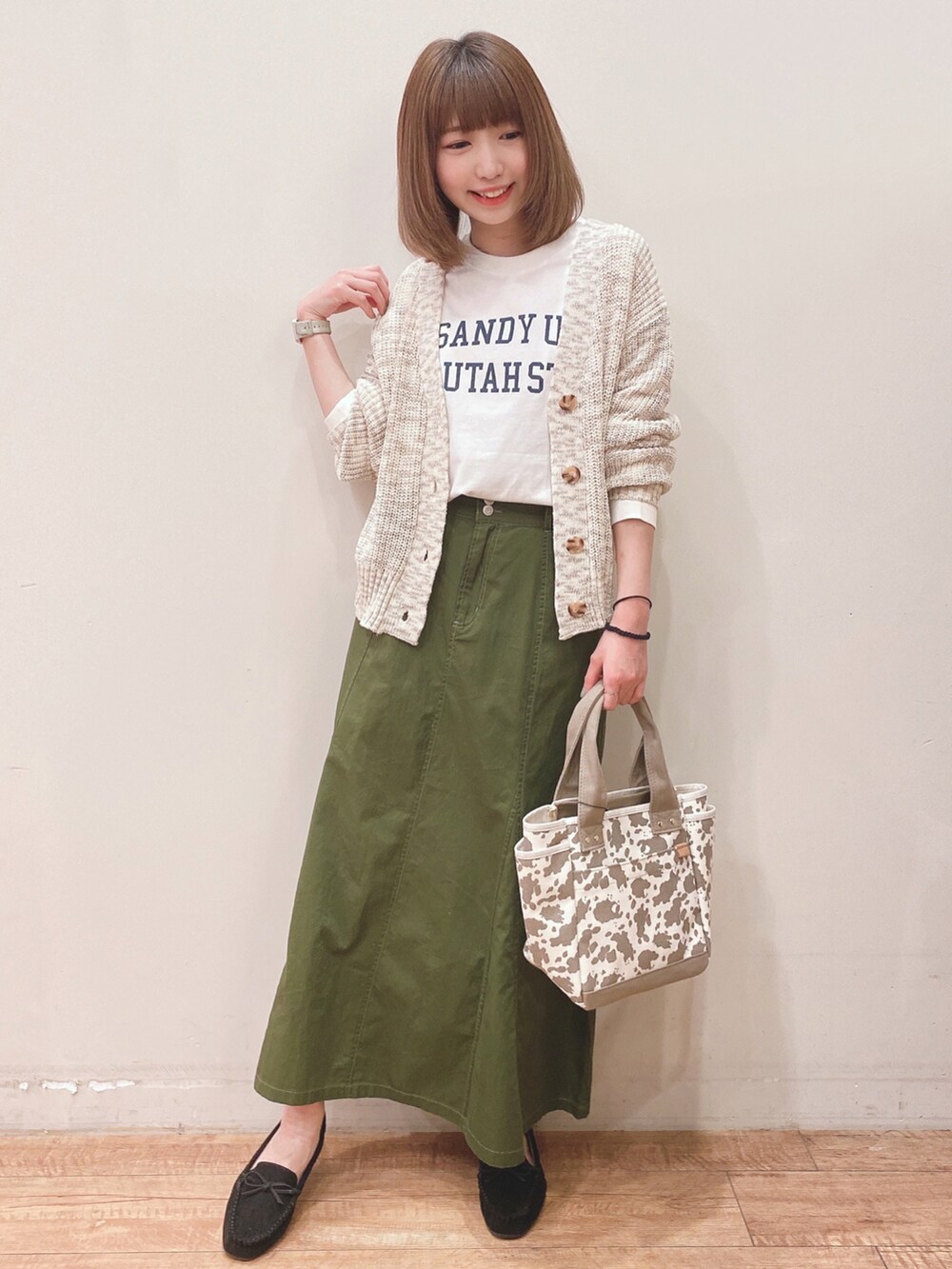 ホワイト系のTシャツ/カットソー、ベージュ系のカーディガン/ボレロ、ブラック系のその他シューズを着用したレディースの春コーディネートの4枚目の写真