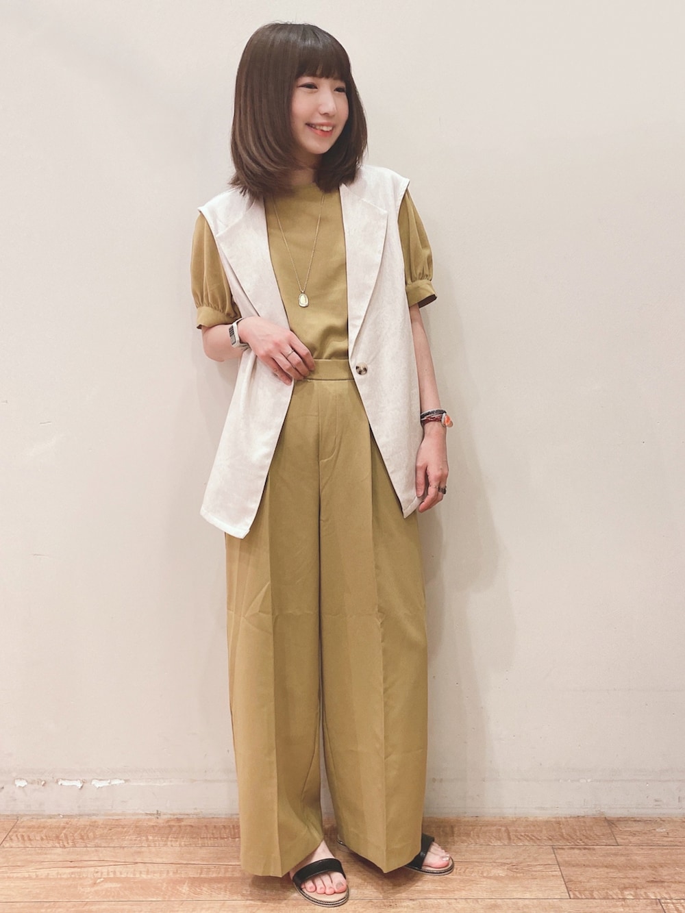 イエロー系のシャツ/ブラウス、イエロー系のその他パンツ、ベージュ系のベストを着用したレディースの春コーディネートの4枚目の写真