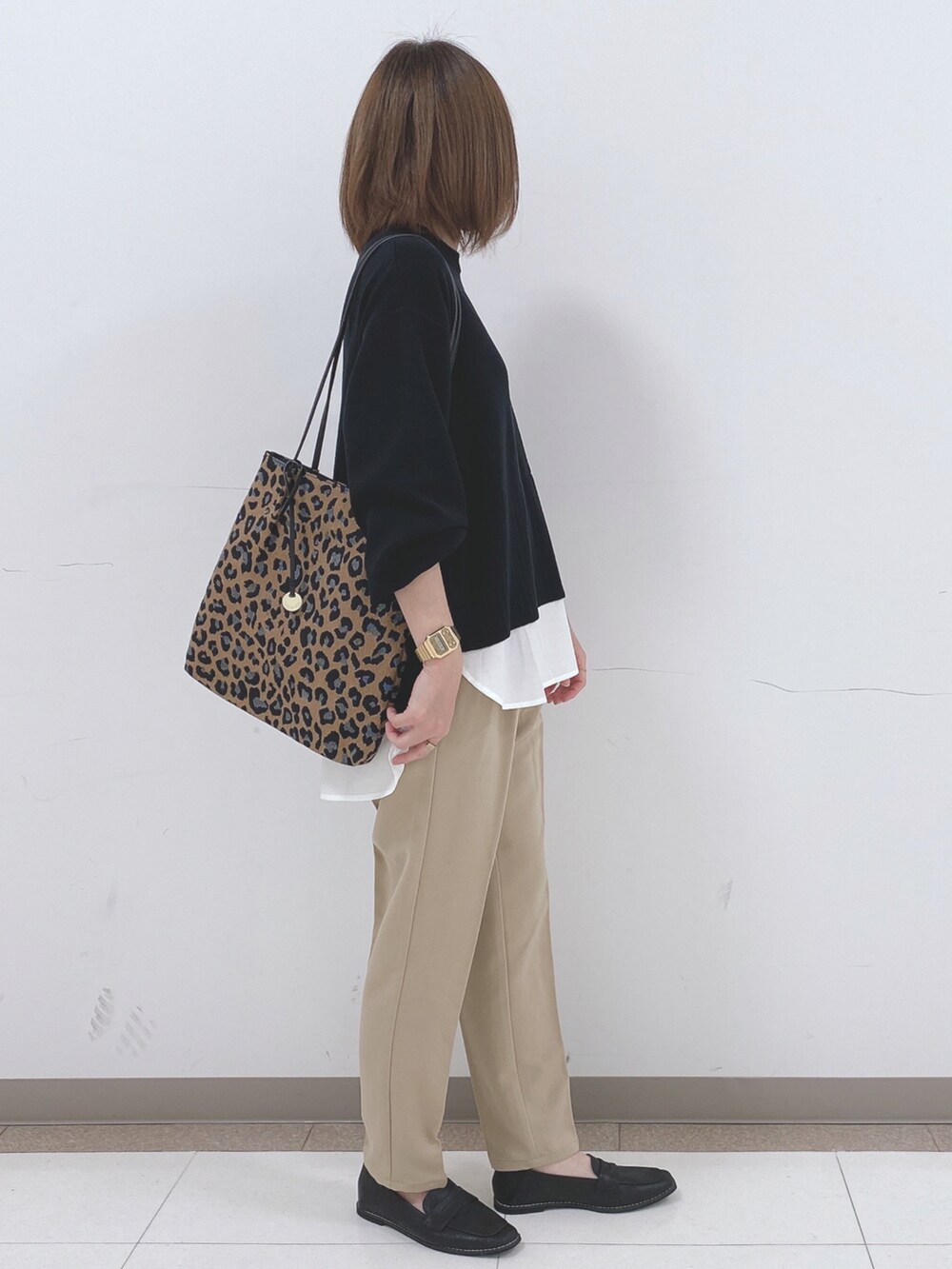 ブラック系のニット/セーター、ベージュ系のその他パンツ、ブラック系のスニーカーを着用したレディースの冬コーディネートの2枚目の写真