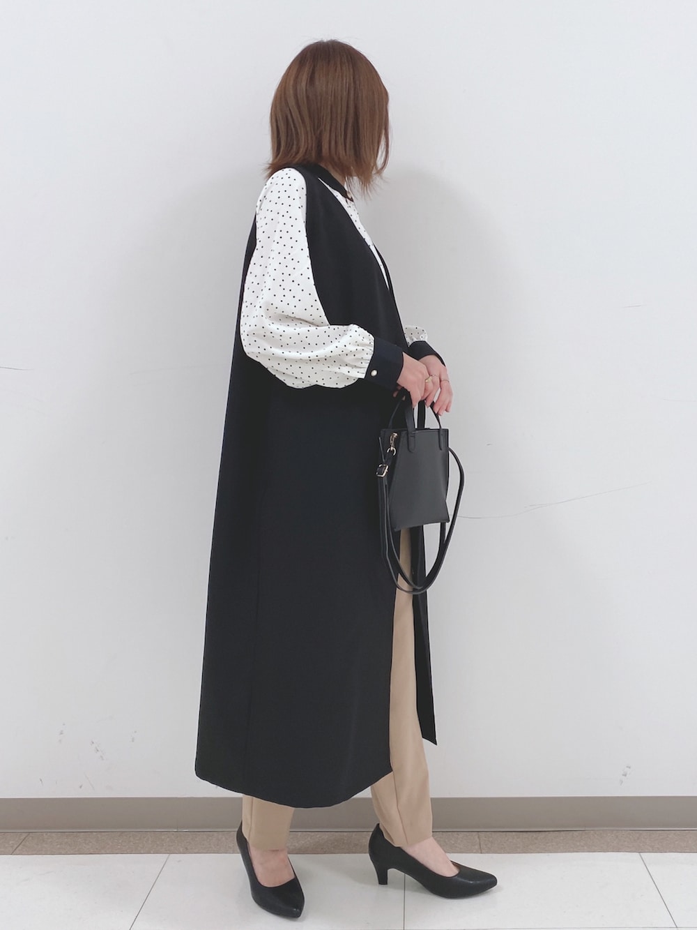 ホワイト系のシャツ/ブラウス、ブラック系のベスト、ベージュ系のその他パンツを着用したレディースの春コーディネートの2枚目の写真