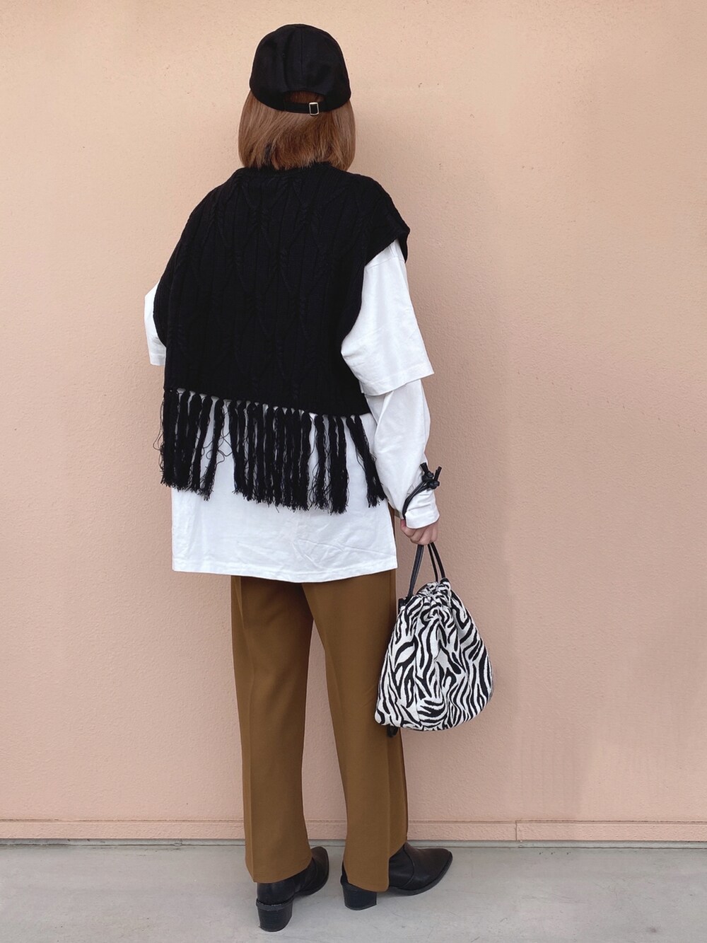 ブラック系のベスト、ホワイト系のTシャツ/カットソー、イエロー系のその他パンツを着用したレディースの冬コーディネートの2枚目の写真