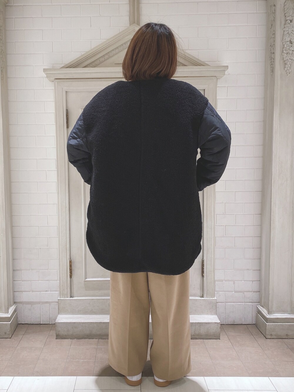 ブラック系のノーカラージャケット、ブラック系のニット/セーター、ベージュ系のその他パンツを着用したレディースの冬コーディネートの3枚目の写真