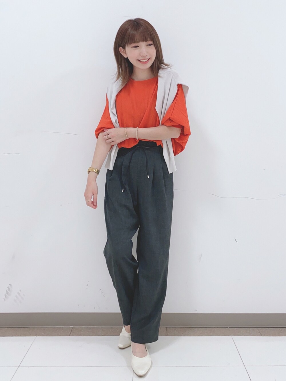 グレー系のカーディガン/ボレロ、オレンジ系のシャツ/ブラウス、グレー系のその他パンツを着用したレディースの春コーディネートの4枚目の写真