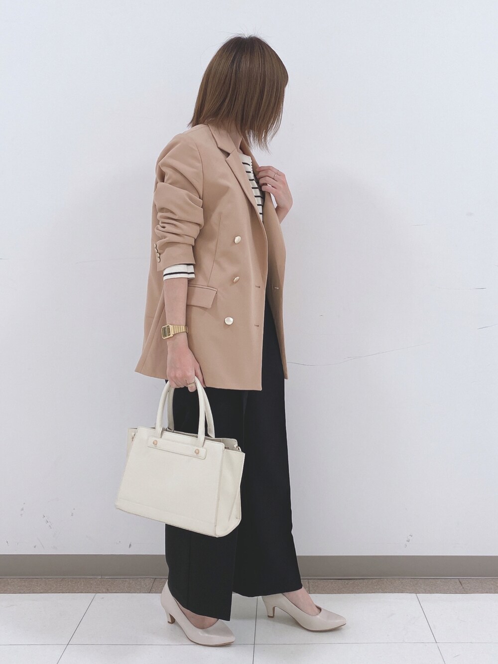 ベージュ系のテーラードジャケット、ホワイト系のニット/セーター、ブラック系のその他パンツを着用したレディースの冬コーディネートの2枚目の写真