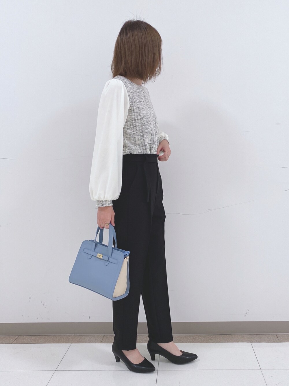 ブラック系のその他パンツ、ブラック系のパンプス、ブルー系のトートバッグを着用したレディースの冬コーディネートの2枚目の写真