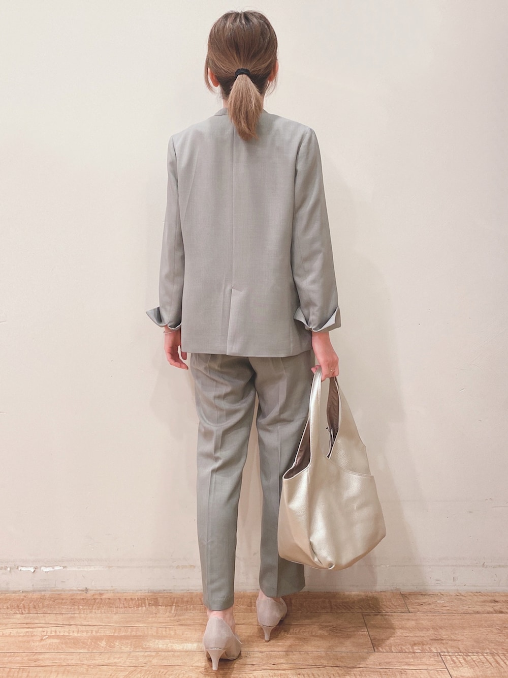 ホワイト系のタンクトップ、グリーン系のノーカラージャケット、ベージュ系のパンプスを着用したレディースの春コーディネートの3枚目の写真