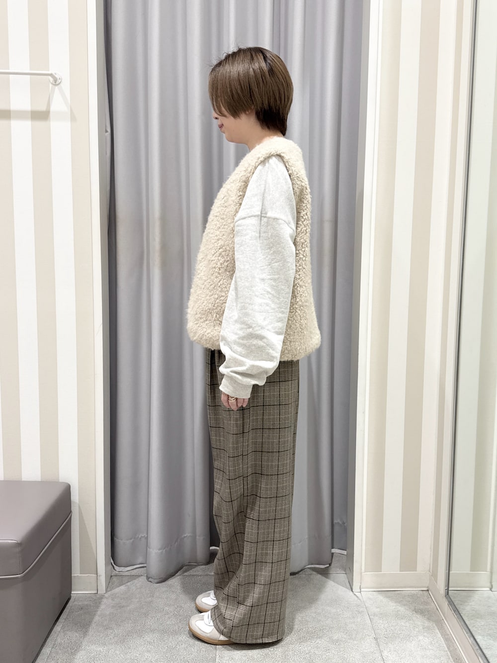 ホワイト系のスウェット、ベージュ系のベスト、ベージュ系のその他パンツを着用したレディースの秋コーディネートの2枚目の写真