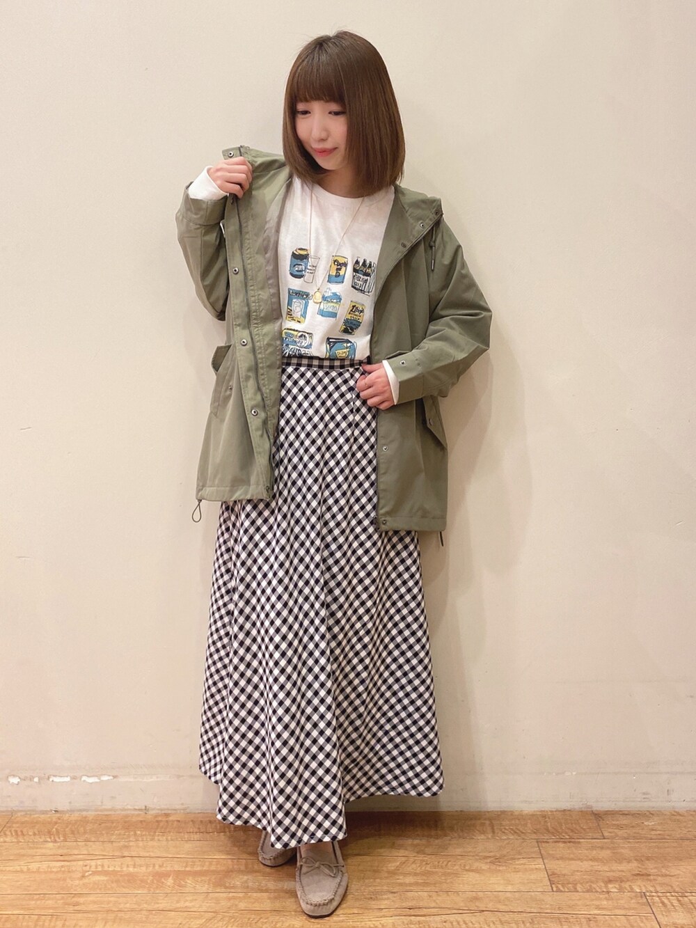 ホワイト系のTシャツ/カットソー、グリーン系のブルゾン、ブラック系のスカートを着用したレディースの春コーディネートの4枚目の写真