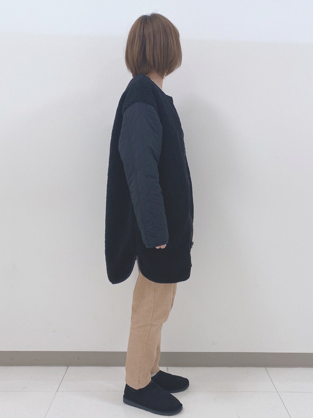 ブラック系のノーカラージャケット、ホワイト系のニット/セーター、イエロー系のその他パンツを着用したレディースの秋コーディネートの2枚目の写真