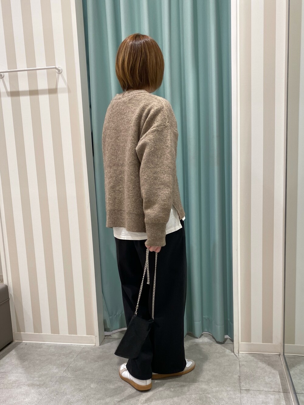 ベージュ系のテーラードジャケット、イエロー系のニット/セーター、ブラック系のその他パンツを着用したレディースの秋コーディネートの5枚目の写真