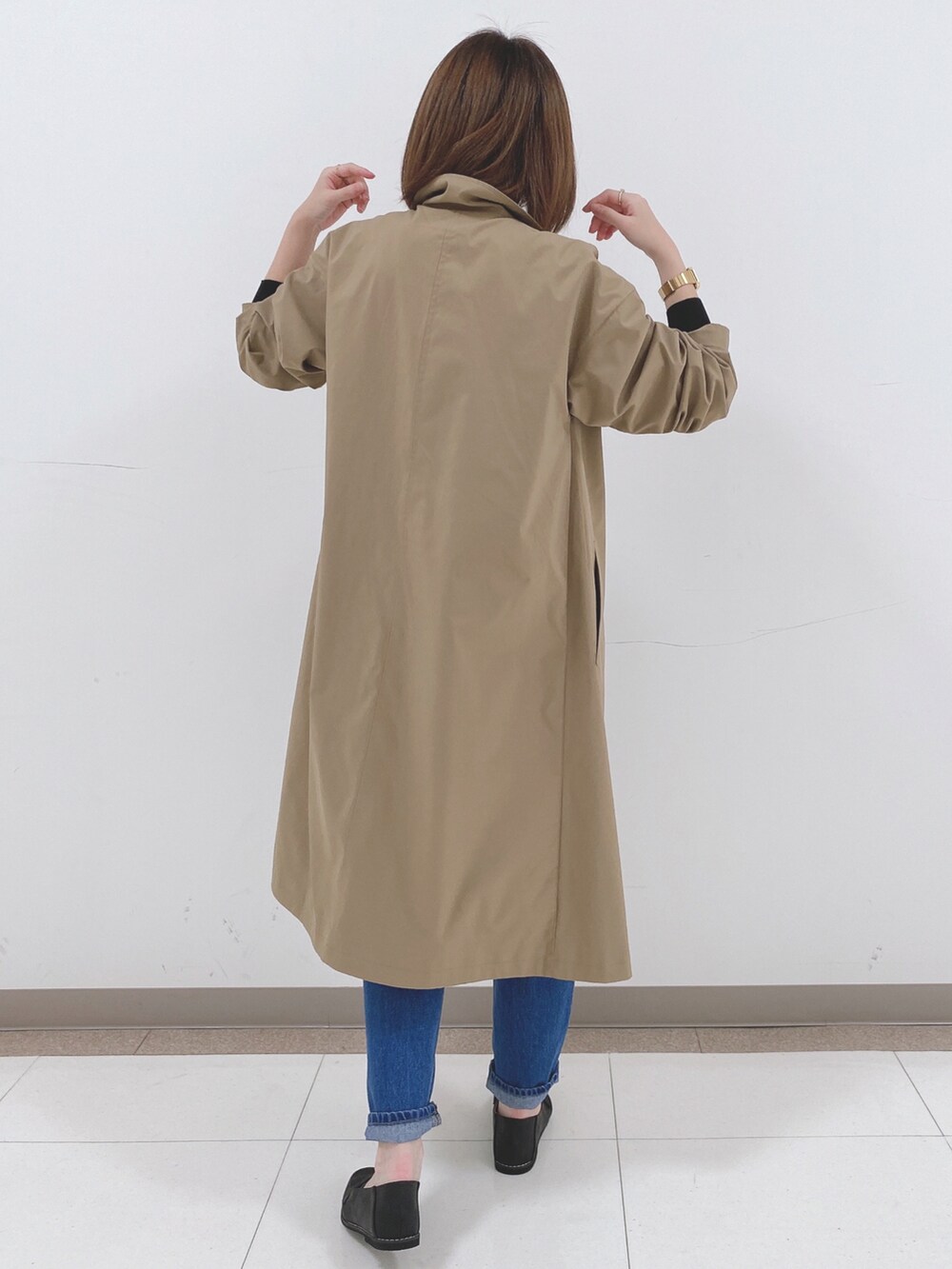 ブラック系のニット/セーター、ベージュ系のその他アウター、ブルー系のデニムパンツを着用したレディースの冬コーディネートの3枚目の写真