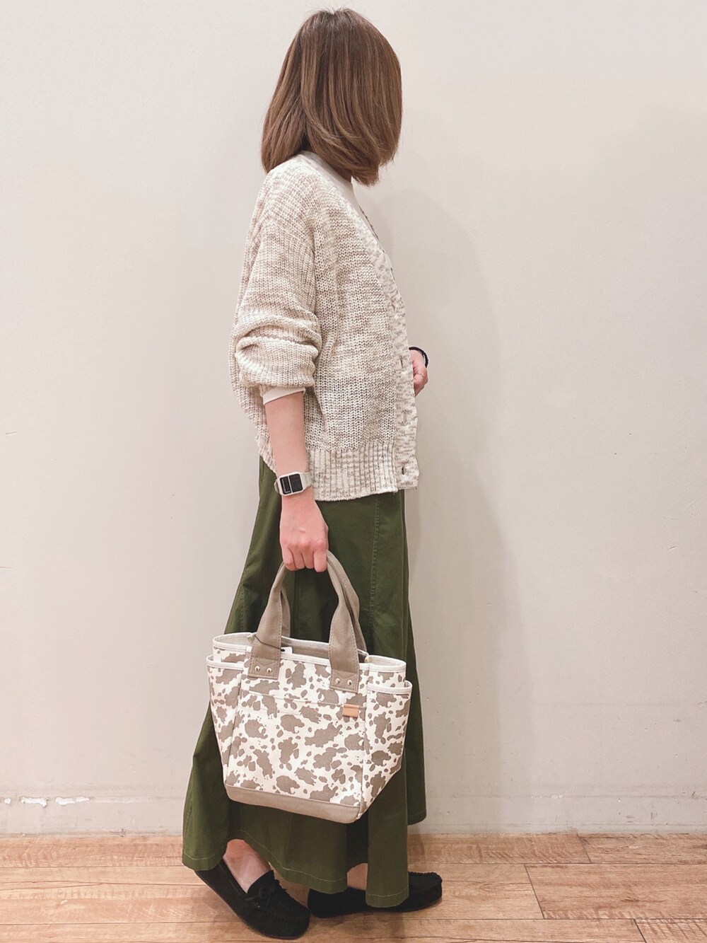 ホワイト系のTシャツ/カットソー、ベージュ系のカーディガン/ボレロ、ブラック系のその他シューズを着用したレディースの春コーディネートの2枚目の写真