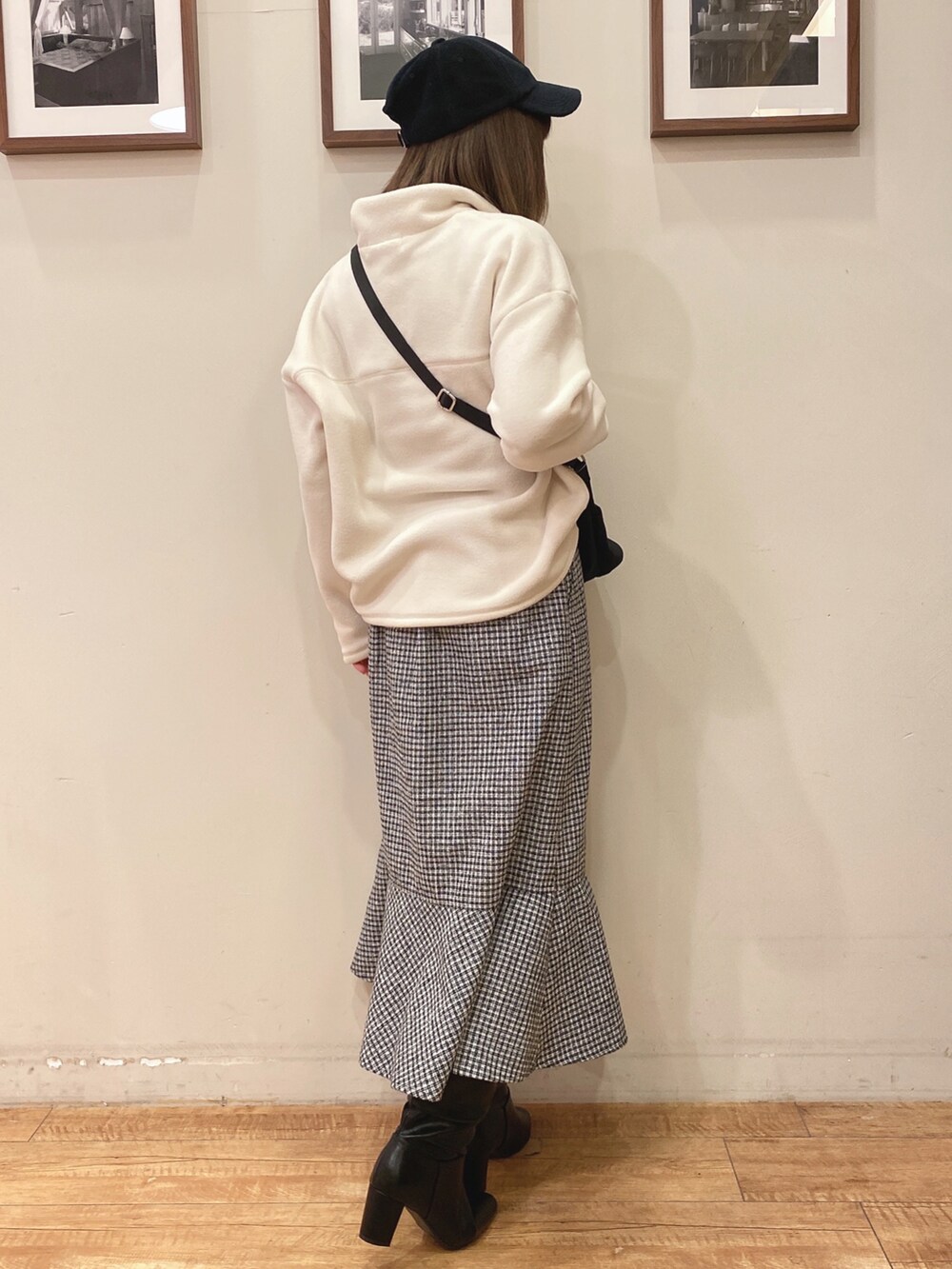 ブラック系のスカート、ホワイト系のTシャツ/カットソー、ブラック系のショルダーバッグを着用したレディースの冬コーディネートの2枚目の写真