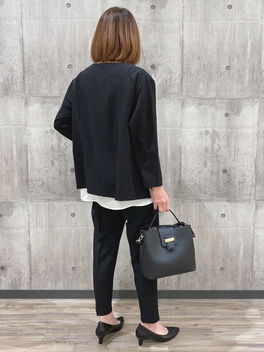 ブラック系のその他トップス、ブラック系のショルダーバッグ、ブラック系のパンプスを着用したレディースの冬コーディネートの2枚目の写真