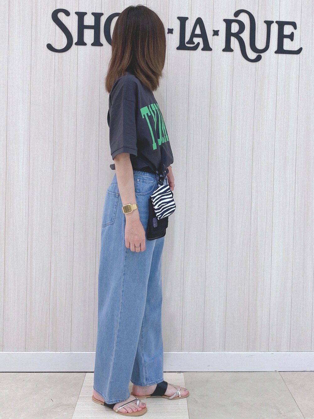 グレー系のTシャツ/カットソー、ブラック系のサンダル、ブラック系のショルダーバッグを着用したレディースの夏コーディネートの2枚目の写真