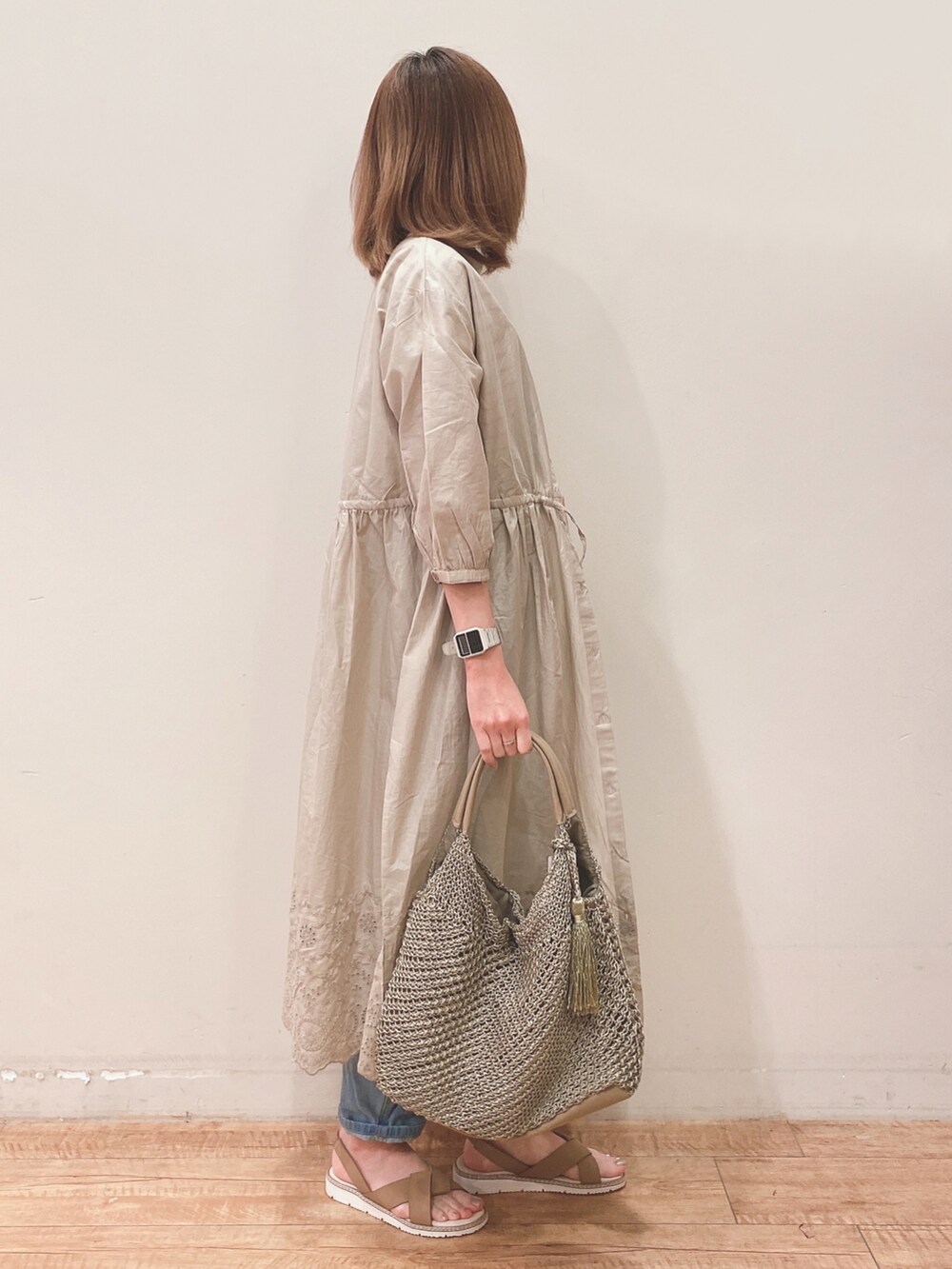 ブルー系のサロペット/オーバーオール、ベージュ系のワンピース、ブラック系のTシャツ/カットソーを着用したレディースの春コーディネートの2枚目の写真