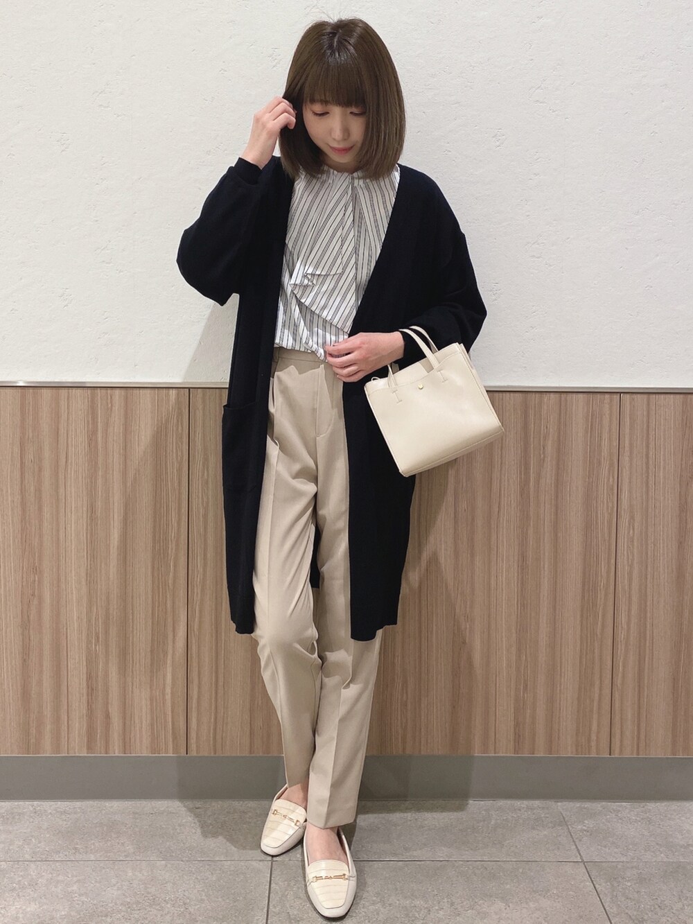グリーン系のシャツ/ブラウス、ホワイト系のショルダーバッグ、ベージュ系のパンツを着用したレディースの春コーディネートの2枚目の写真