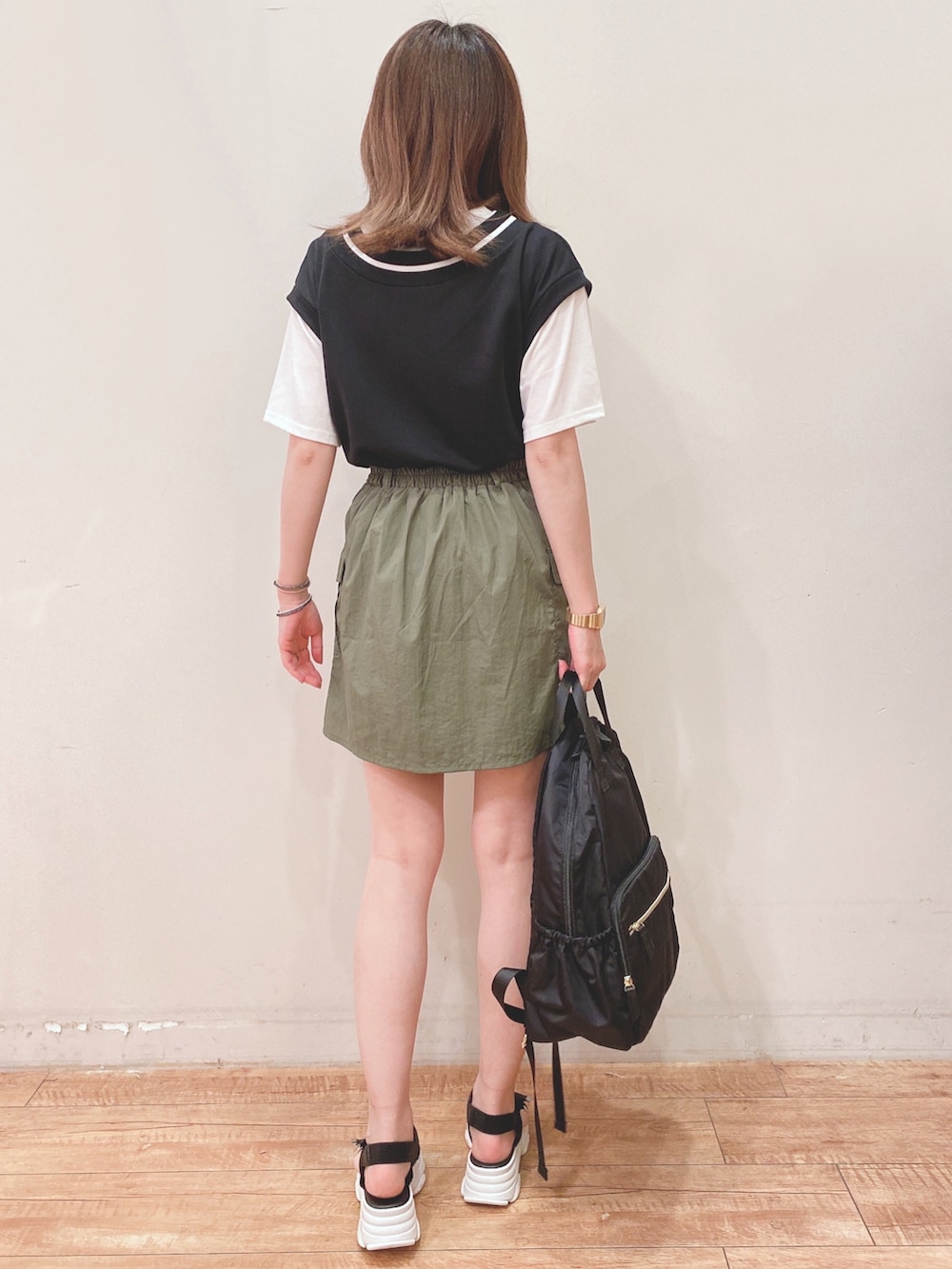 ブラック系のTシャツ/カットソー、グリーン系のスカート、ブラック系のサンダルを着用したレディースの夏コーディネートの3枚目の写真