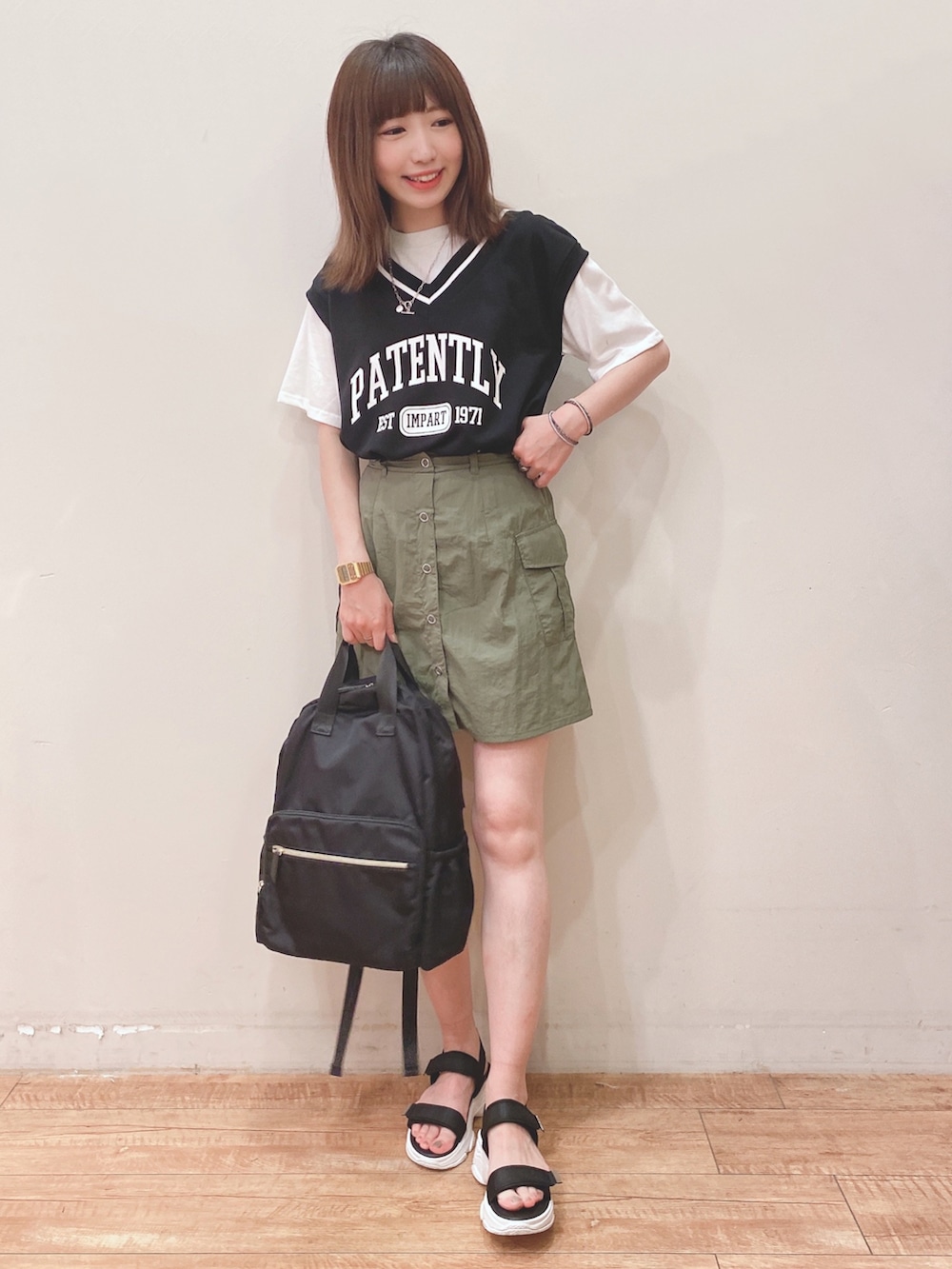 ブラック系のTシャツ/カットソー、グリーン系のスカート、ブラック系のサンダルを着用したレディースの夏コーディネートの4枚目の写真