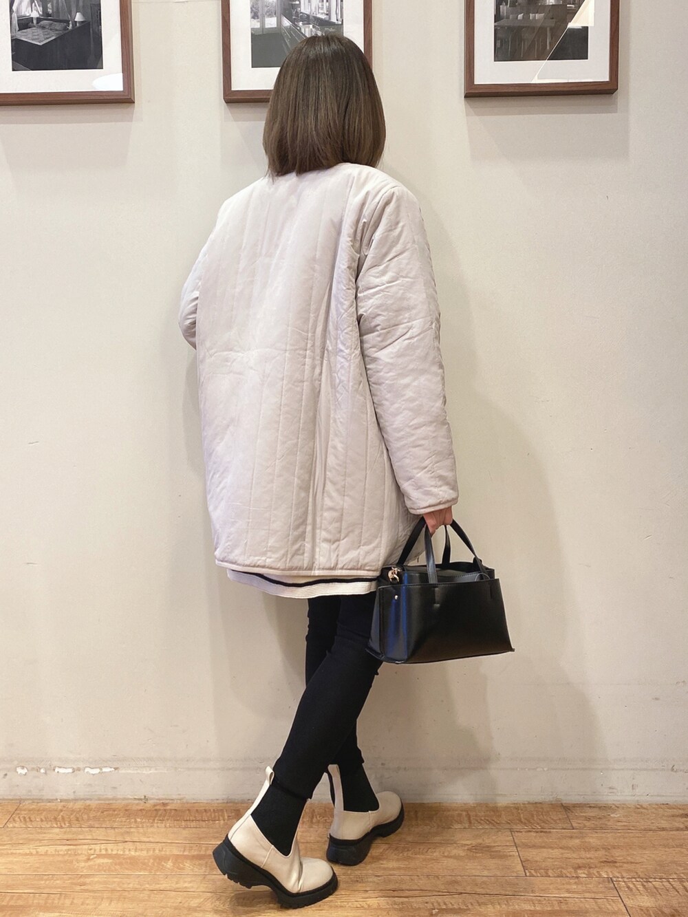 ホワイト系のその他アウター、ベージュ系のワンピース、ブラック系のショルダーバッグを着用したレディースの冬コーディネートの2枚目の写真