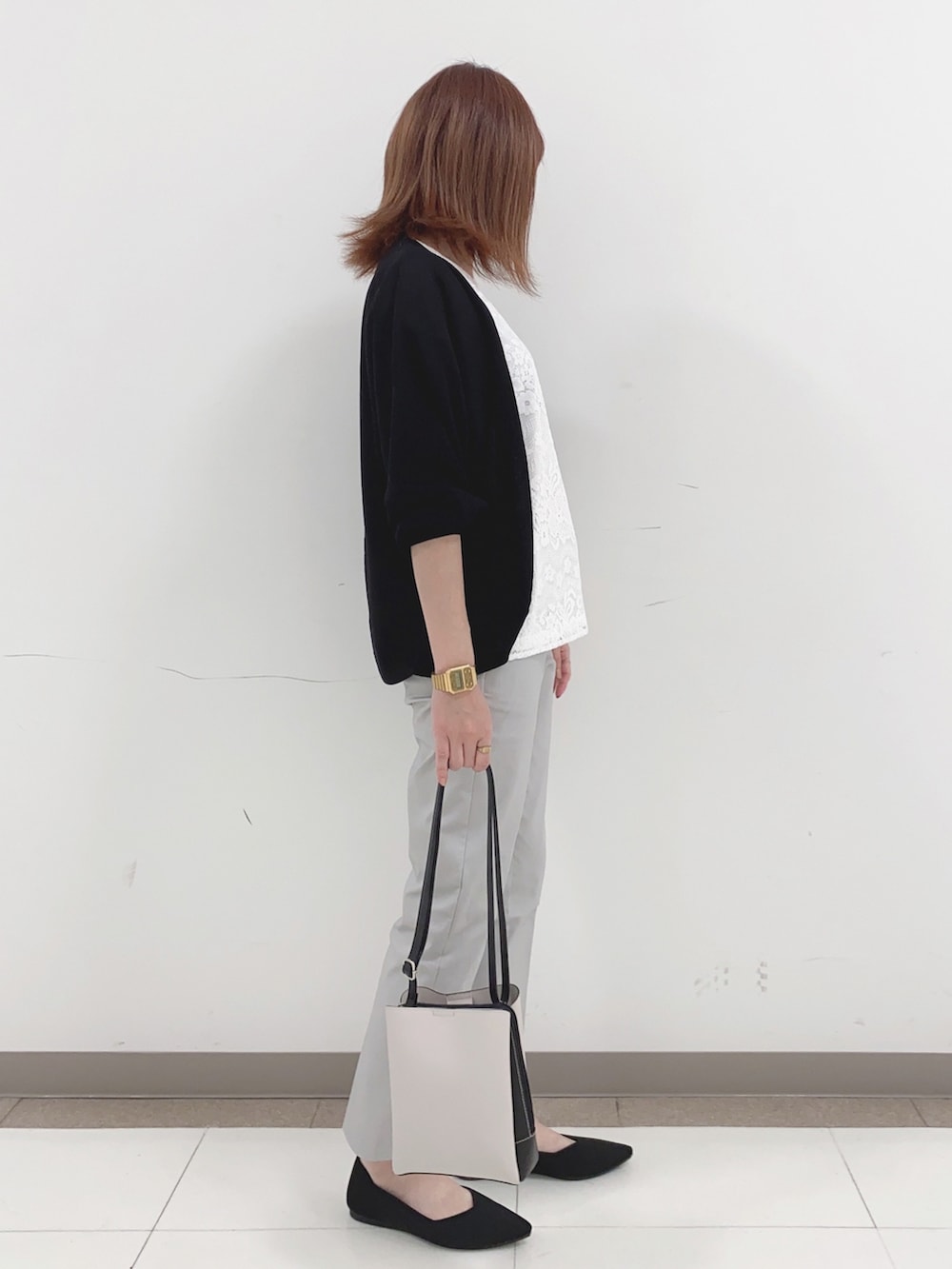 ホワイト系のTシャツ/カットソー、ブラック系のカーディガン/ボレロ、グレー系のその他パンツを着用したレディースの春コーディネートの2枚目の写真