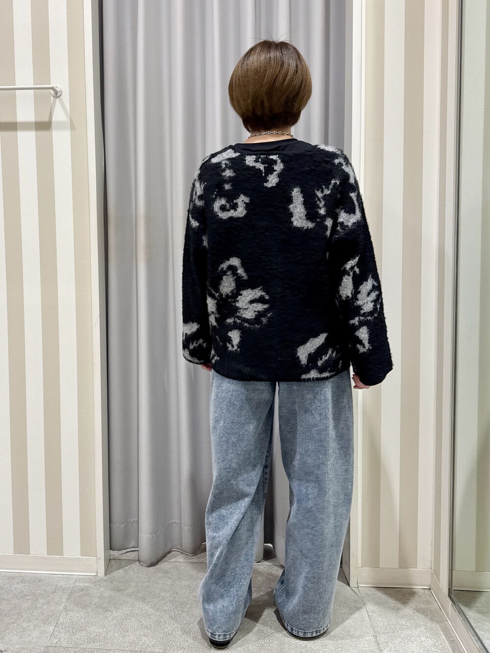 ブラック系のカーディガン/ボレロ、ブラック系のTシャツ/カットソー、ブルー系のデニムパンツを着用したレディースの秋コーディネートの3枚目の写真