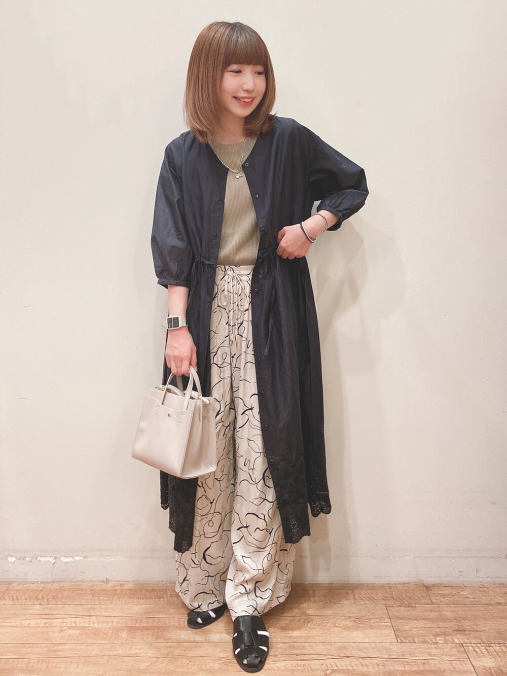 グリーン系のタンクトップ、ブラック系のワンピース、ベージュ系のその他パンツを着用したレディースの春コーディネートの4枚目の写真