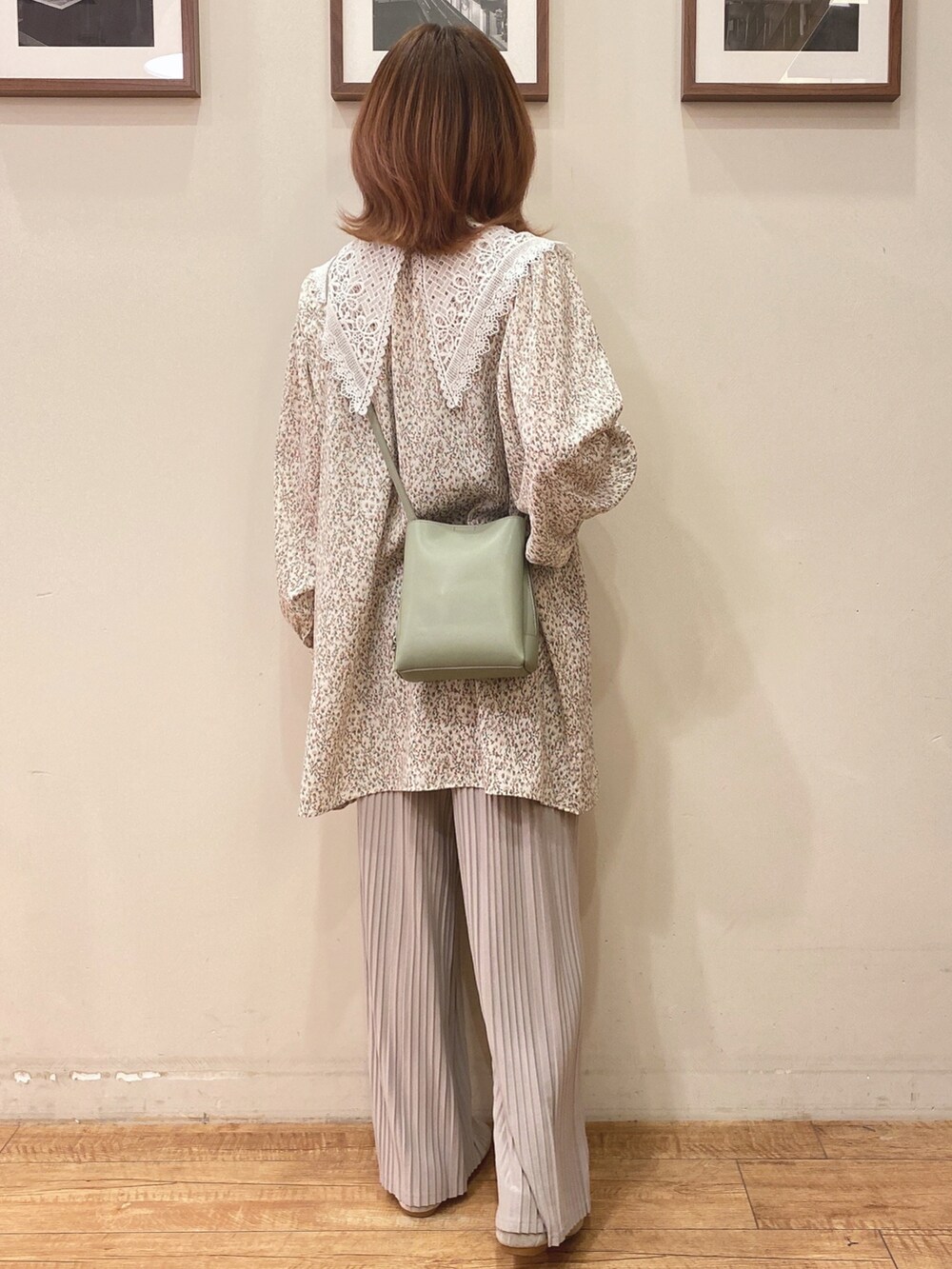 ベージュ系のチュニック、グリーン系のショルダーバッグ、グレー系のその他パンツを着用したレディースの冬コーディネートの2枚目の写真