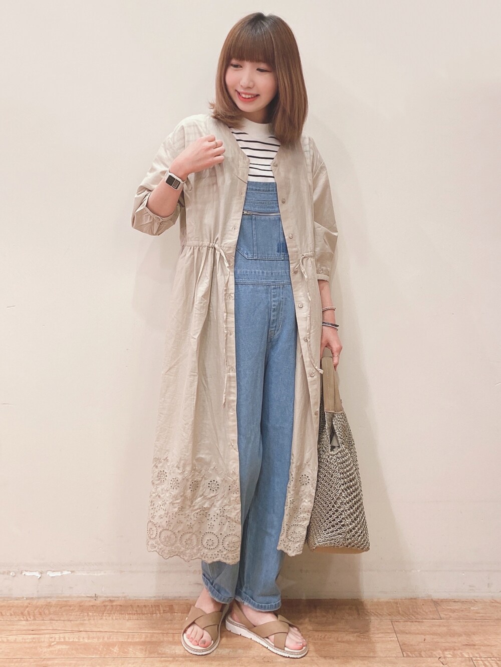 ブルー系のサロペット/オーバーオール、ベージュ系のワンピース、ブラック系のTシャツ/カットソーを着用したレディースの春コーディネートの4枚目の写真