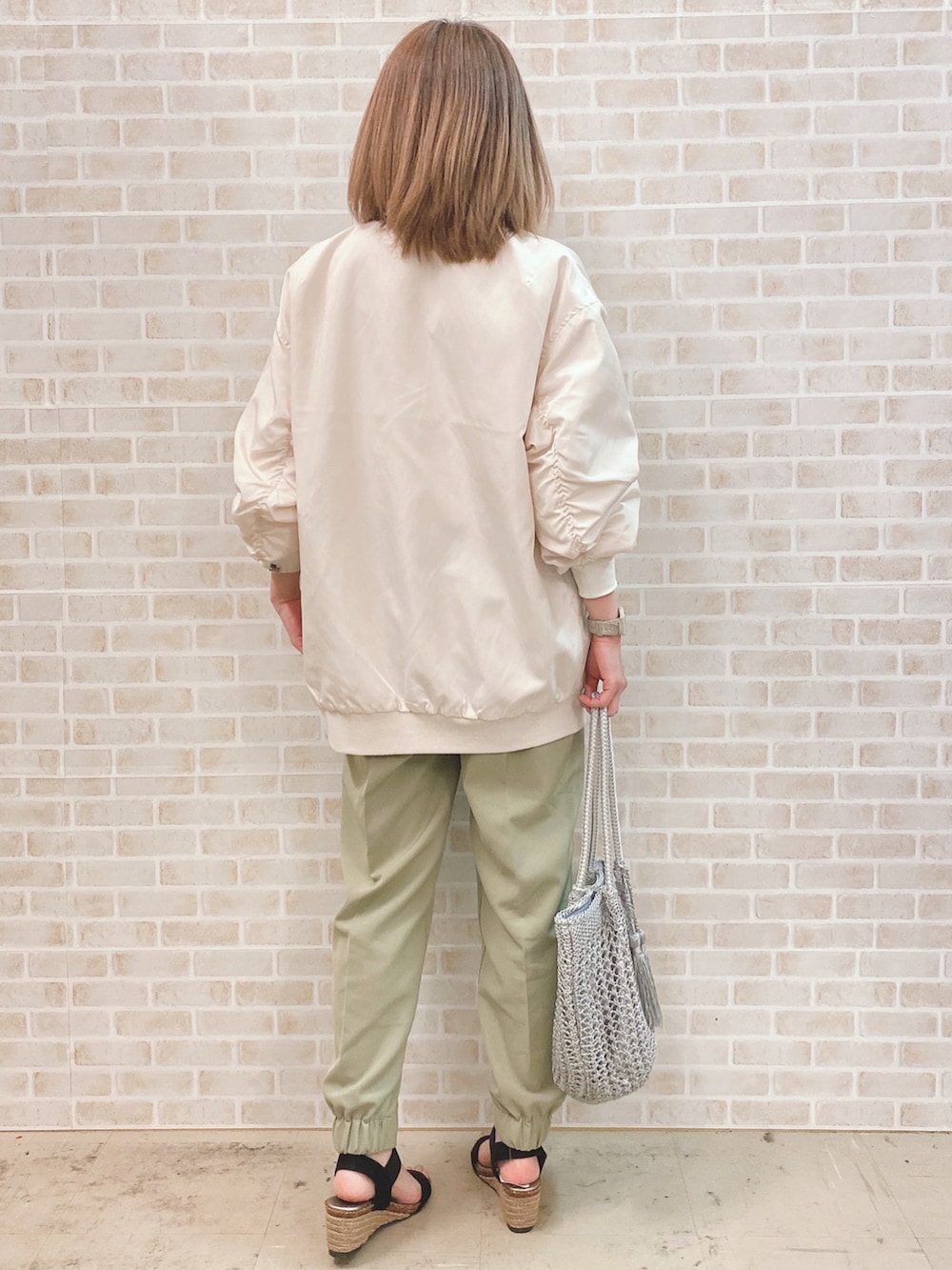 ホワイト系のTシャツ/カットソー、ベージュ系のブルゾン、グリーン系のその他パンツを着用したレディースの春コーディネートの3枚目の写真